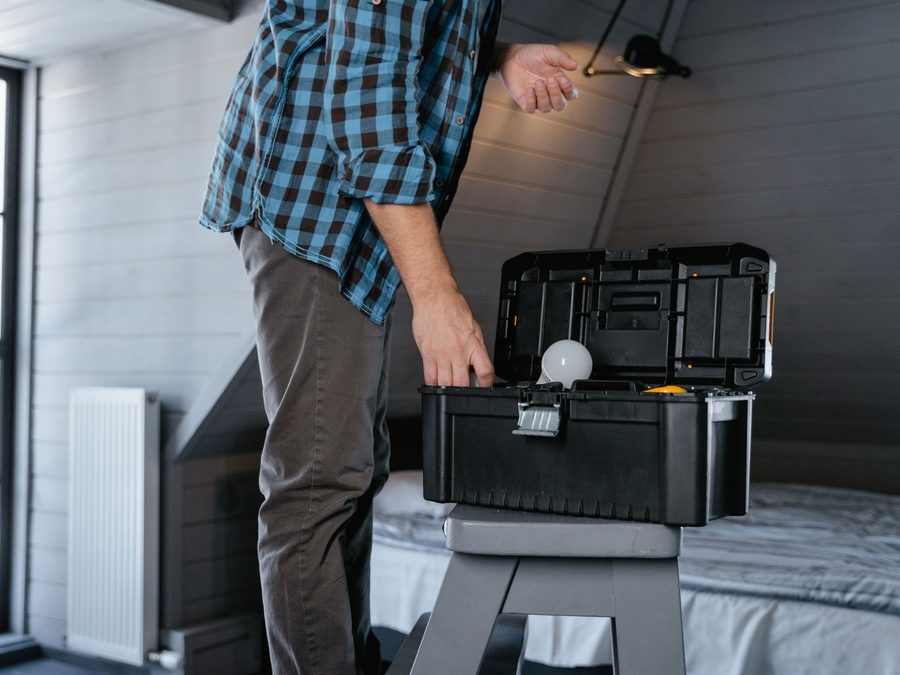 Handyman with an open toolbox working inside a home